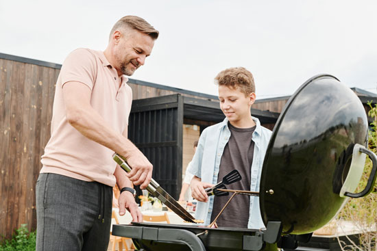 Father and children grilling food at a BBQ party